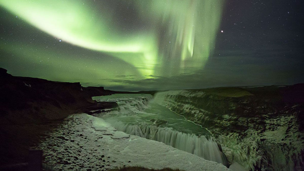 GULLFOSS WATERFALL IN ICELAND WITH NORTHERN LIGHTS DANCING ABOVE