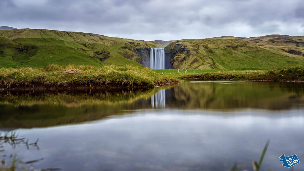 Skogaoss waterfall in South of Iceland reflecting in river