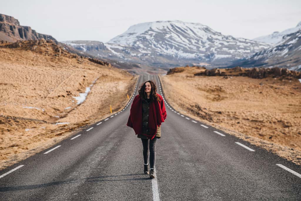Happy woman walking on ring road in Iceland